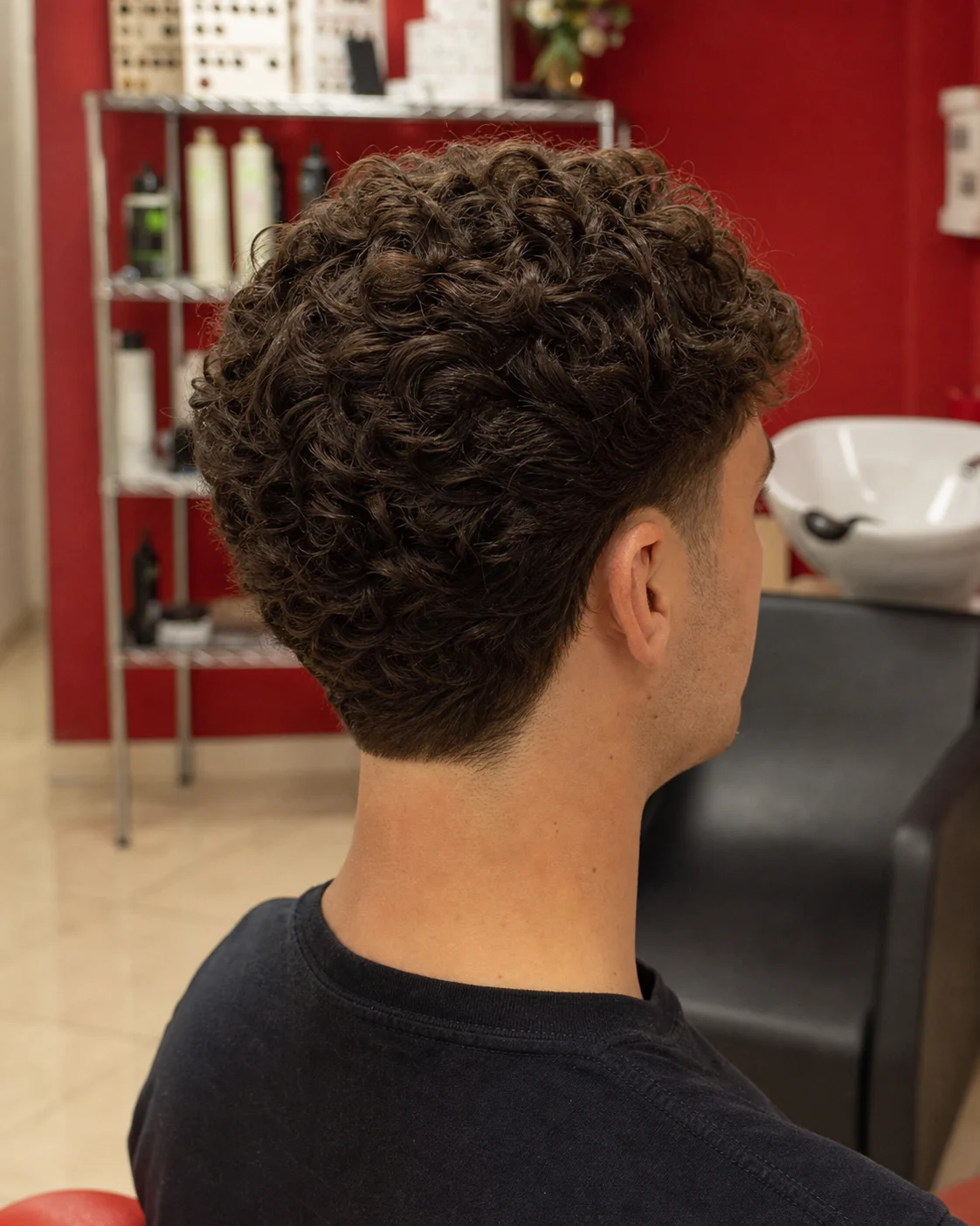 Taglio uomo riccio con taper pulito