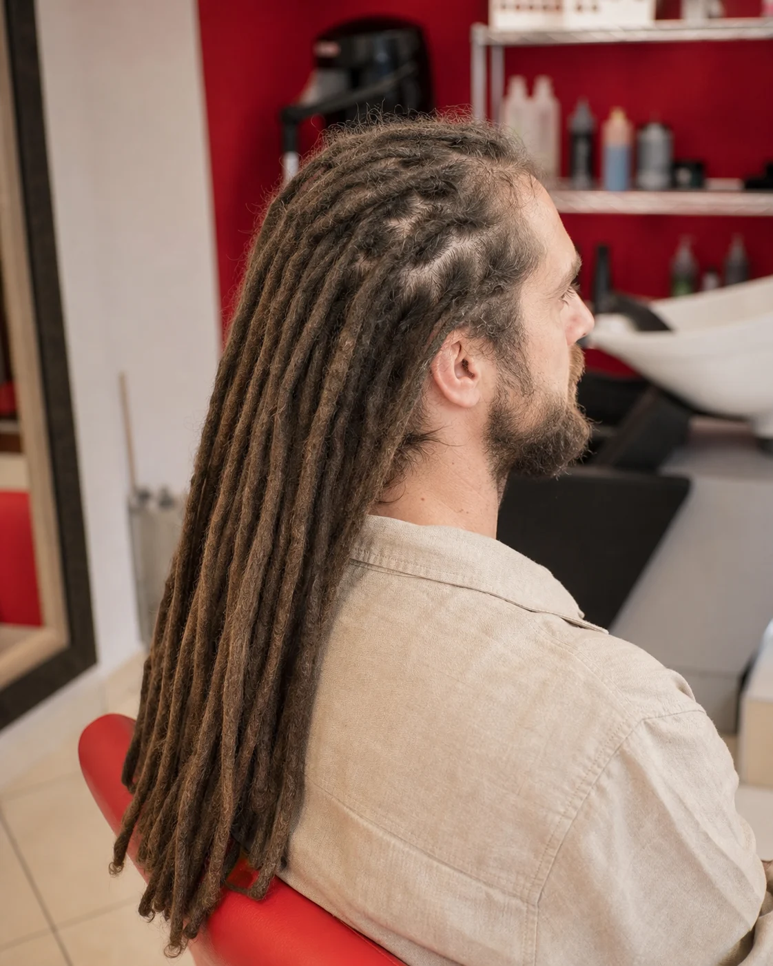 Uomo con dreadlocks lunghi curati in salone